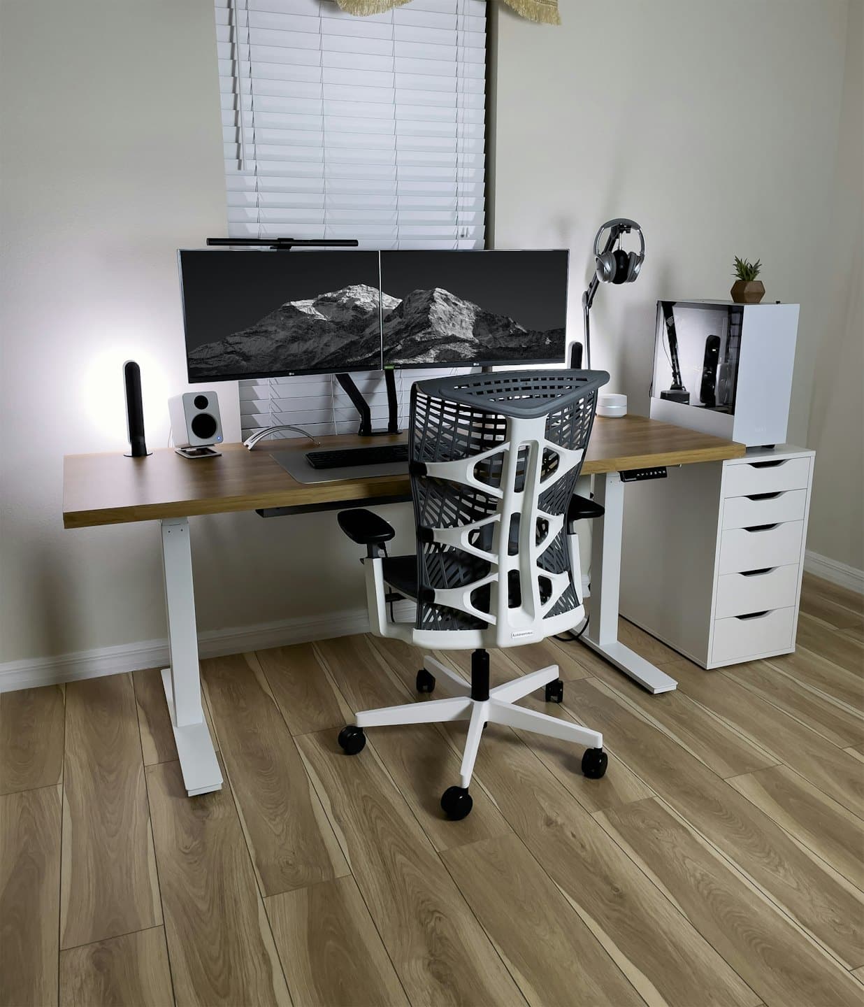 Ufficio domestico minimalista con doppio monitor e scrivania in legno.