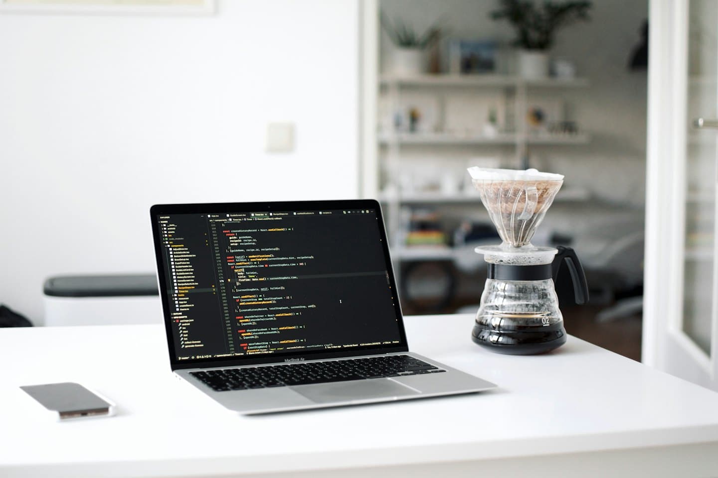Un laptop con codice su una scrivania con una tazza di caffè.