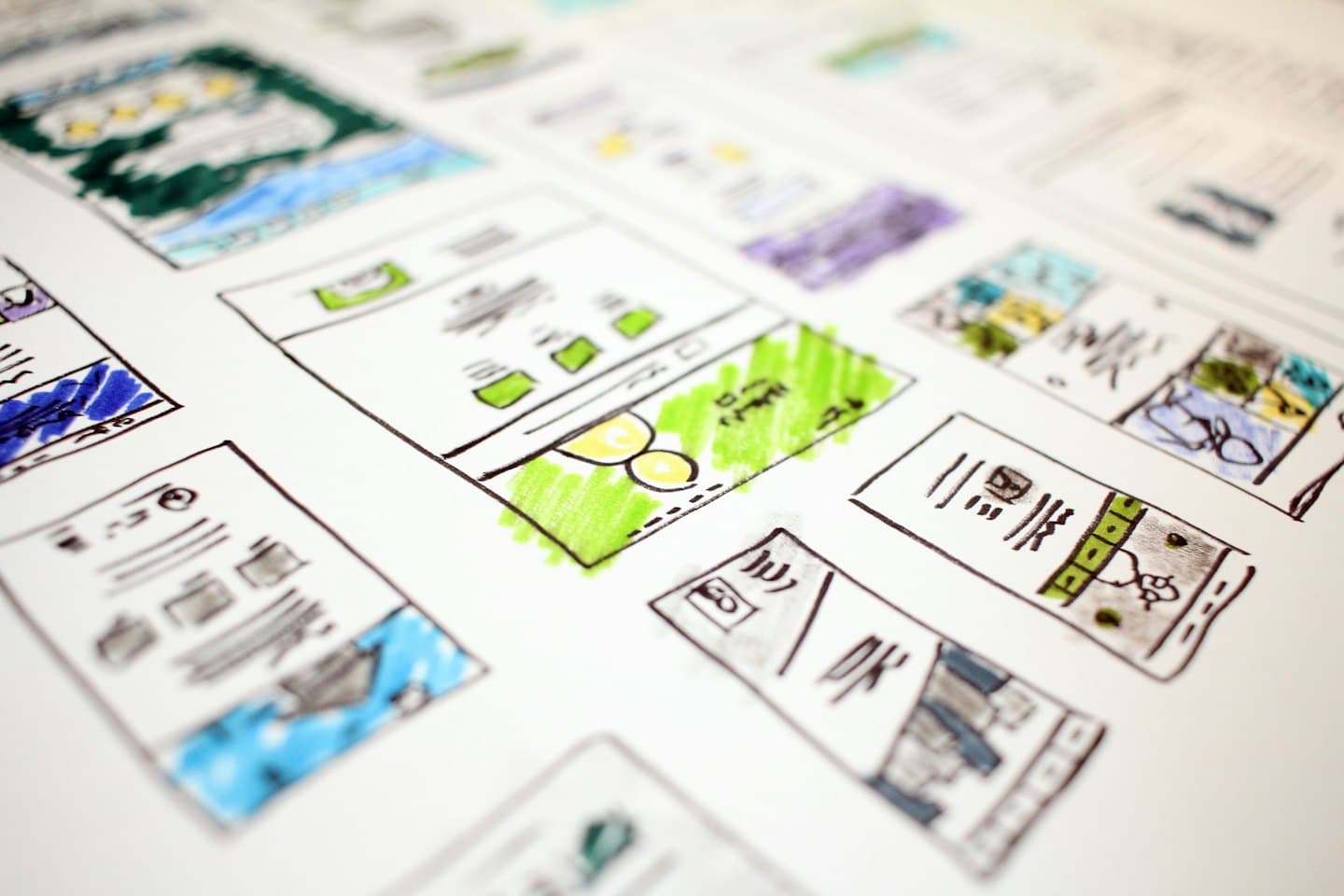 Schizzi wireframe disegnati a mano di layout di siti web con pennarelli colorati.
